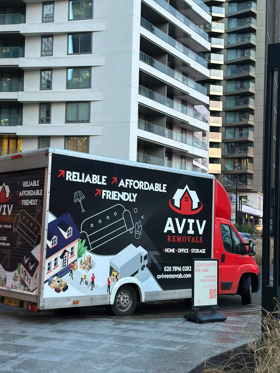 House removal in progress outside a modern London apartment block, Aviv Removals van on site